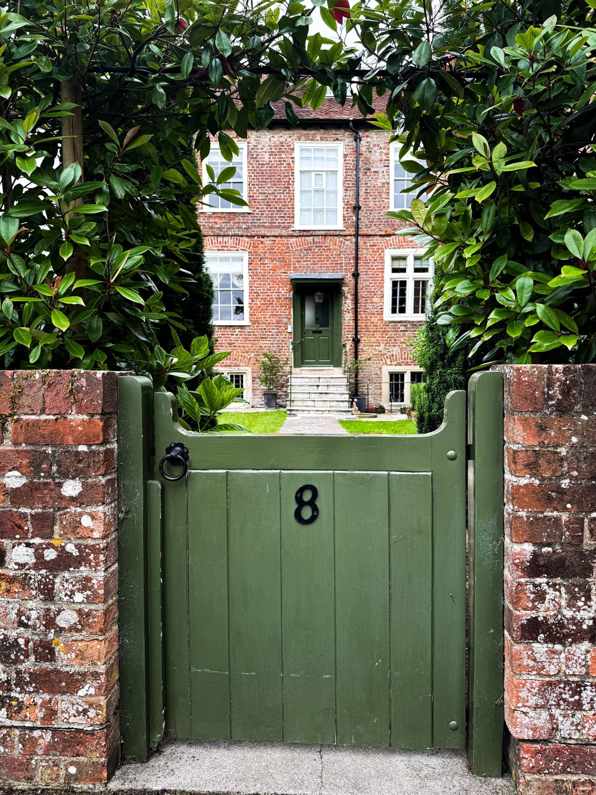 Stock example: painted timber garden gate set in a brick boundary wall in Salisbury, England